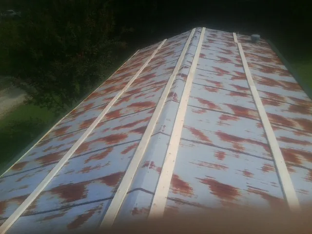 Rusted metal roof panels with new wood purlins before replacement — Storm Damage Roof Repair in Ridgecrest by Roofing Brothers