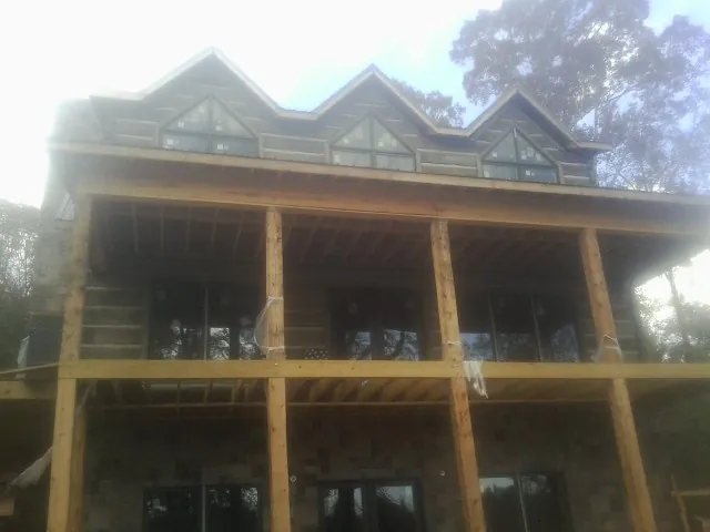 Dormers and porch framing on a large log home under construction — Roof Coating work by our crew in Ridgecrest