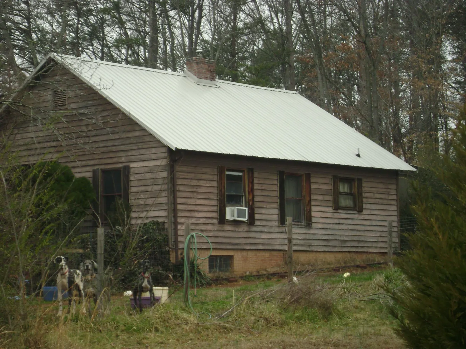 White metal roof on an old wood sided farmhouse, from a Metal Roof Installation job in Ridgecrest